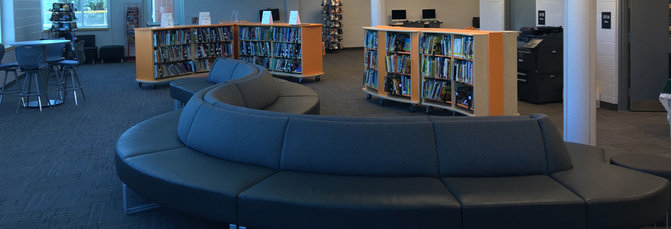 Tables, chairs, books in the Learning Commons area